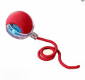 Red rolling pet toy with attached rope on a white background